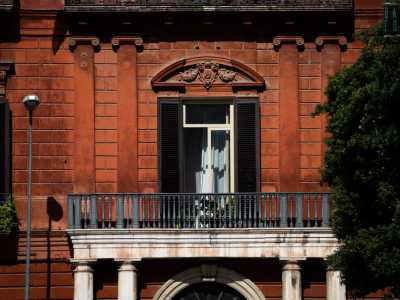 ...stesso materiale di cui sono fatte le quattro colonne di media altezza che lo affiancano e che sostengono il balcone del piano nobile